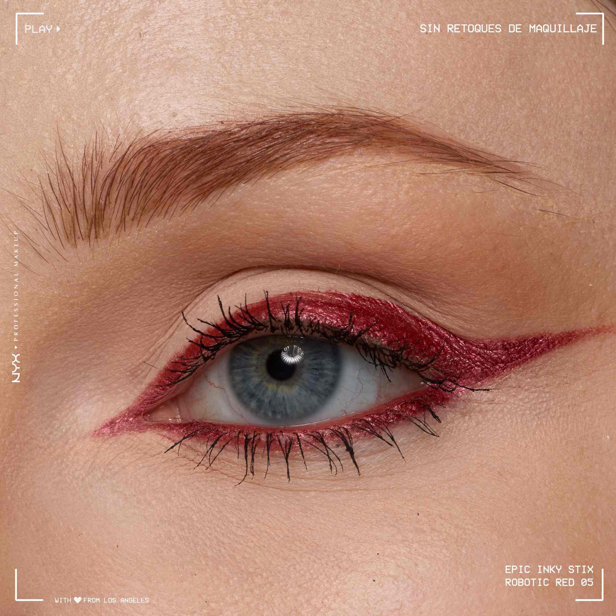 Close of a model wearing Epic Inky Stix on the top of their eyelid as a winged liner style in shade 04 Robotic Red