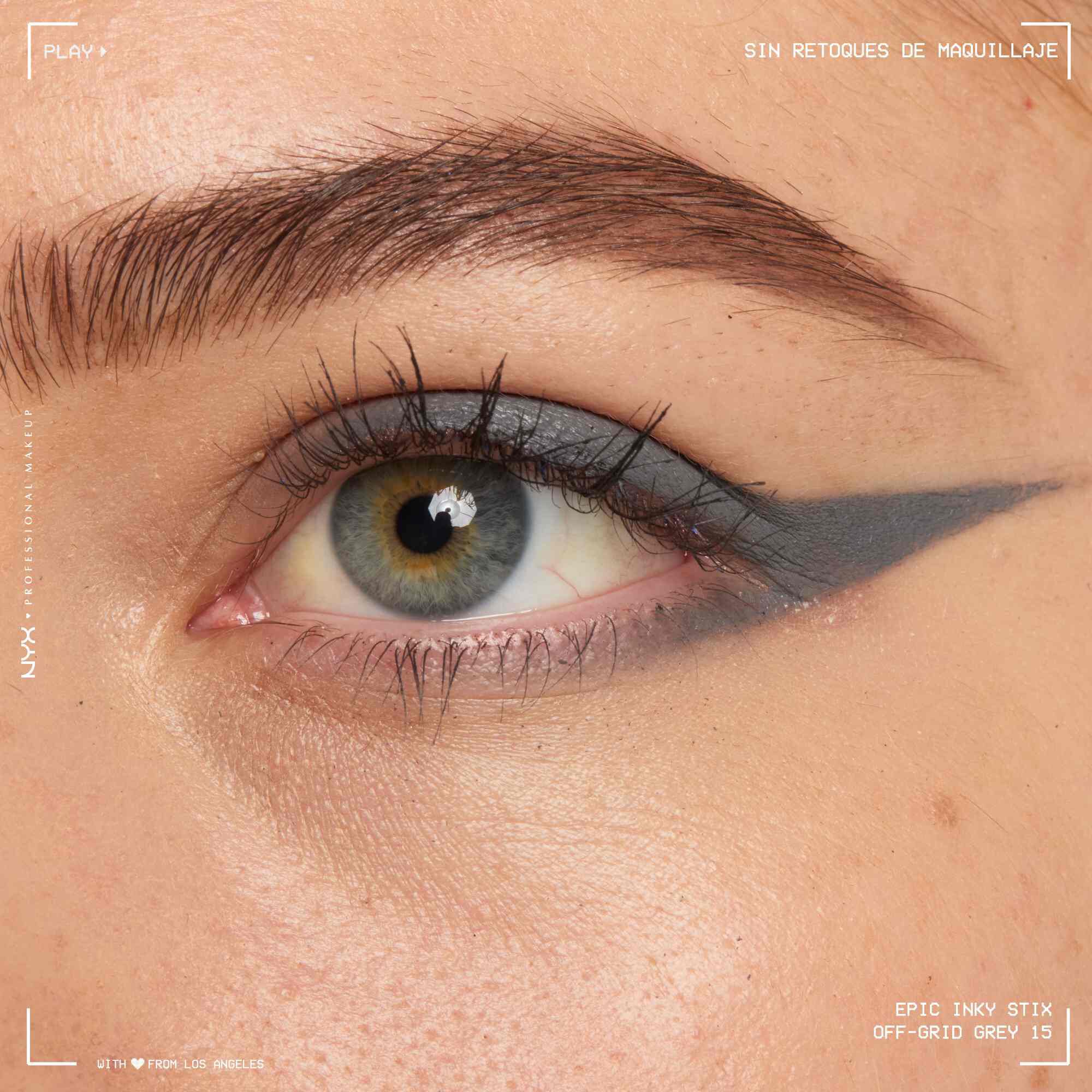 Close of a model wearing Epic Inky Stix on the top of their eyelid as a winged liner style in shade 15 Off-Grid Grey