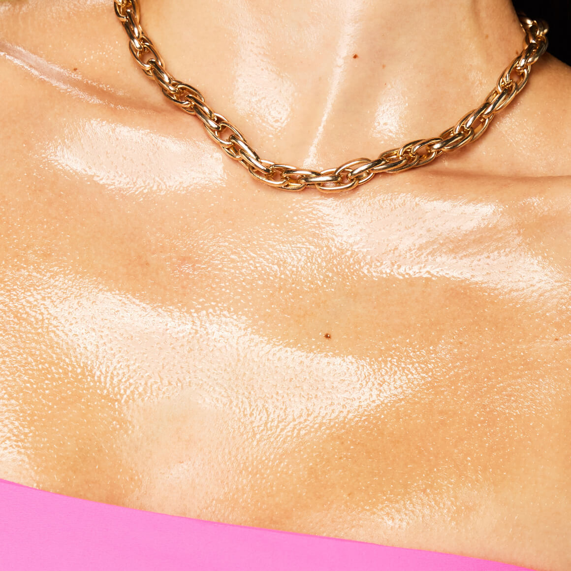 Image of the model’s chest after applying NYX Professional Makeup Fat Oil Body Oil in Suga Baddie showing a smooth, high-shine finish.